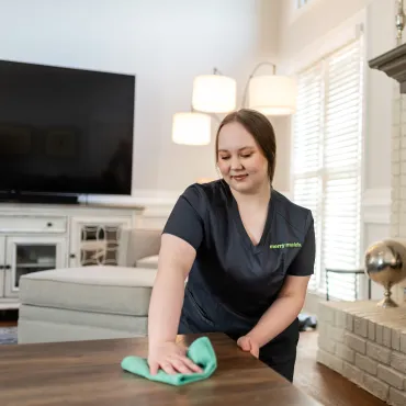 Merry Maids Team Member Dusting Coffee Table